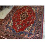 TABRIZ RUG, indigo and beige medallion on a deep red field, royal blue, ivory and salmon