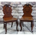 PAIR OF VICTORIAN WALNUT HALL CHAIRS, carved shield backs, solid seats and scrolled legs, 94cms high