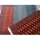 THREE MODERN AFGHAN-STYLE RUGS, identical Bakhara designs in pink, red and teal fields, 170 x 120cms