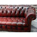 VICTORIAN-STYLE LEATHER CHESTERFIELD SOFA, red button upholstered and close nailed on turned feet,