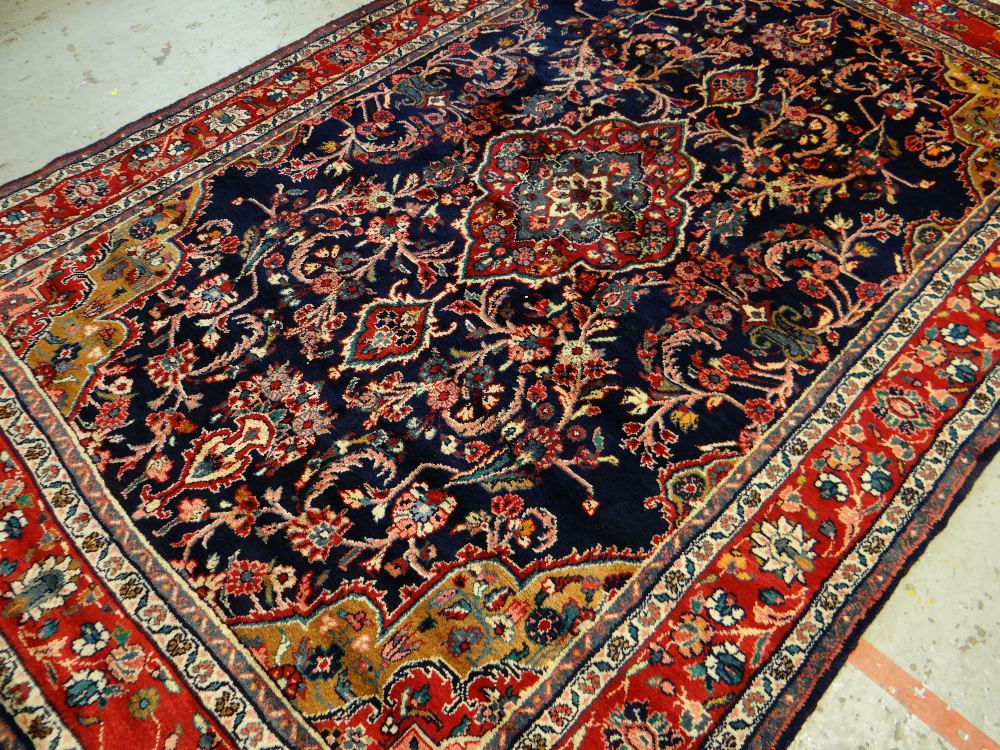 TABRIZ-STYLE RUG, red medallion on an indigo field with caramel and pink spandrels, red palmette