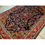 TABRIZ-STYLE RUG, red medallion on an indigo field with caramel and pink spandrels, red palmette