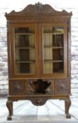 CARVED FLEMISH OAK BOOKCASE ON STAND, shaped cornice above laurel frieze, glazed doors between