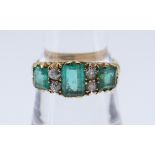 18CT GOLD DIAMOND & EMERALD RING the central emerald 7 x 5mms, ring size P, 5.0gms, in red square