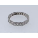 18CT WHITE GOLD HALF ETERNITY RING set with ten diamonds and overall engraved, ring size O, 4.5 gms,