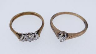 TWO 9CT GOLD DIAMOND RINGS comprising one single stone (stamped 0.30cts) and one three stone, 3.6gms