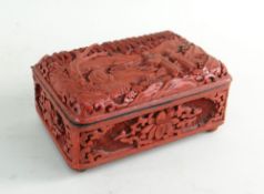 CHINESE CINNABAR LACQUER BOX, hinged cover carved with luohan in a landscape, sides with panels of