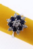 18CT WHITE GOLD SAPPHIRE & DIAMOND CLUSTER RING of flower head design comprising six sapphire and