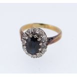 18CT GOLD SAPPHIRE & DIAMOND CLUSTER RING, the central sapphire (7 x 5mms) surrounded by twelve