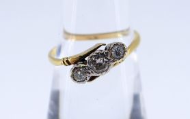 YELLOW METAL THREE STONE DIAMOND RING, illusion set on twist shank, 0.2cts overall approximately,