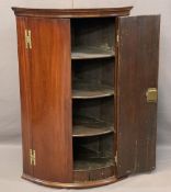 ANTIQUE MAHOGANY BOW FRONT HANGING CORNER CUPBOARD, brass H hinges and twin opening doors,