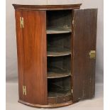 ANTIQUE MAHOGANY BOW FRONT HANGING CORNER CUPBOARD, brass H hinges and twin opening doors,