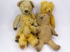 FOUR PLAYWORN VINTAGE TEDDY BEARS in wool and plush mohair, all with jointed limbs, 40cms L the