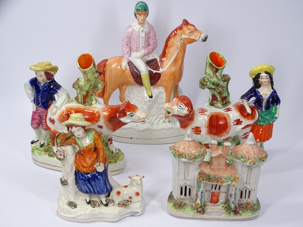 STAFFORDSHIRE COW SPILL HOLDERS, other figural groups and a cottage including a Jockey on horseback,