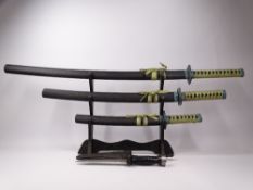 SET OF JAPANESE DISPLAY SWORDS ON STAND and a US Aqualung diver's knife with holster