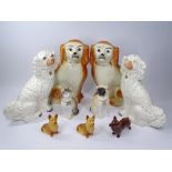 STAFFORDSHIRE & OTHER POTTERY DOG FIGURINES and a biscuit porcelain cat, 34cms H the largest pair