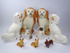 STAFFORDSHIRE & OTHER POTTERY DOG FIGURINES and a biscuit porcelain cat, 34cms H the largest pair