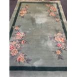 GREEN GROUND CHINESE WASHED WOOLLEN RUG, G H Ffrith Ltd with corner floral sprays, single band