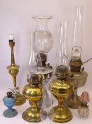 OIL LAMPS & LIGHTING an assortment with accompanying chimneys and an etched glass shade