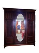 CIRCA 1900 INLAID MAHOGANY TRIPLE WARDROBE having central oval mirrored door and flanking boxwood