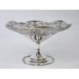 A SILVER TAZZA ON A PEDESTAL BASE - the pedestal with scrolled rim and the tazza having a wide,