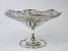 A SILVER TAZZA ON A PEDESTAL BASE - the pedestal with scrolled rim and the tazza having a wide,