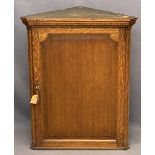 VINTAGE OAK WALL HANGING CORNER CUPBOARD having a dentil cornice and quarter cut pillars flanking