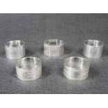 NAPKIN RINGS - 1. A pair of sterling silver engine turned wide rings, each with a small initial, 1.