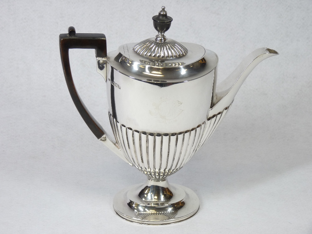 A SILVER COFFEE POT - of oval form with half reeded body to a shallow pedestal, handle and knop