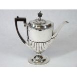 A SILVER COFFEE POT - of oval form with half reeded body to a shallow pedestal, handle and knop