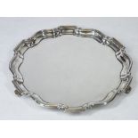A SMALL SILVER CIRCULAR LETTER TRAY - uninscribed with wavy border on three scroll supports,