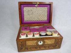 AN OBLONG MULTI-WOOD INLAID & LIDDED SEWING BOX - with interior partitioned tray together with the