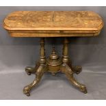 VICTORIAN WALNUT FOLDOVER CARD TABLE - on turned and carved supports and central urn finial on brown