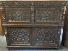 CONTINENTAL CARVED OAK CUPBOARD - of good colour having two top drawers with seahorse and mask