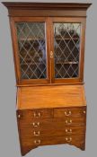 MAHOGANY BUREAU CABINET - upper section with leaded glass doors, the lower section with two short