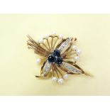 A 9CT GOLD LEAF/FLORAL BROOCH - three central sapphires (or similar) with three diamond encrusted