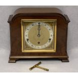 ELLIOTT OF LONDON WALNUT CASED MANTEL CLOCK - having winged mask spandrels and silvered chapter ring