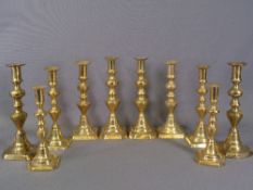 BRASS CANDLESTICKS - five pairs, similarly shaped, graduated from 24cms the tallest to 20cms the