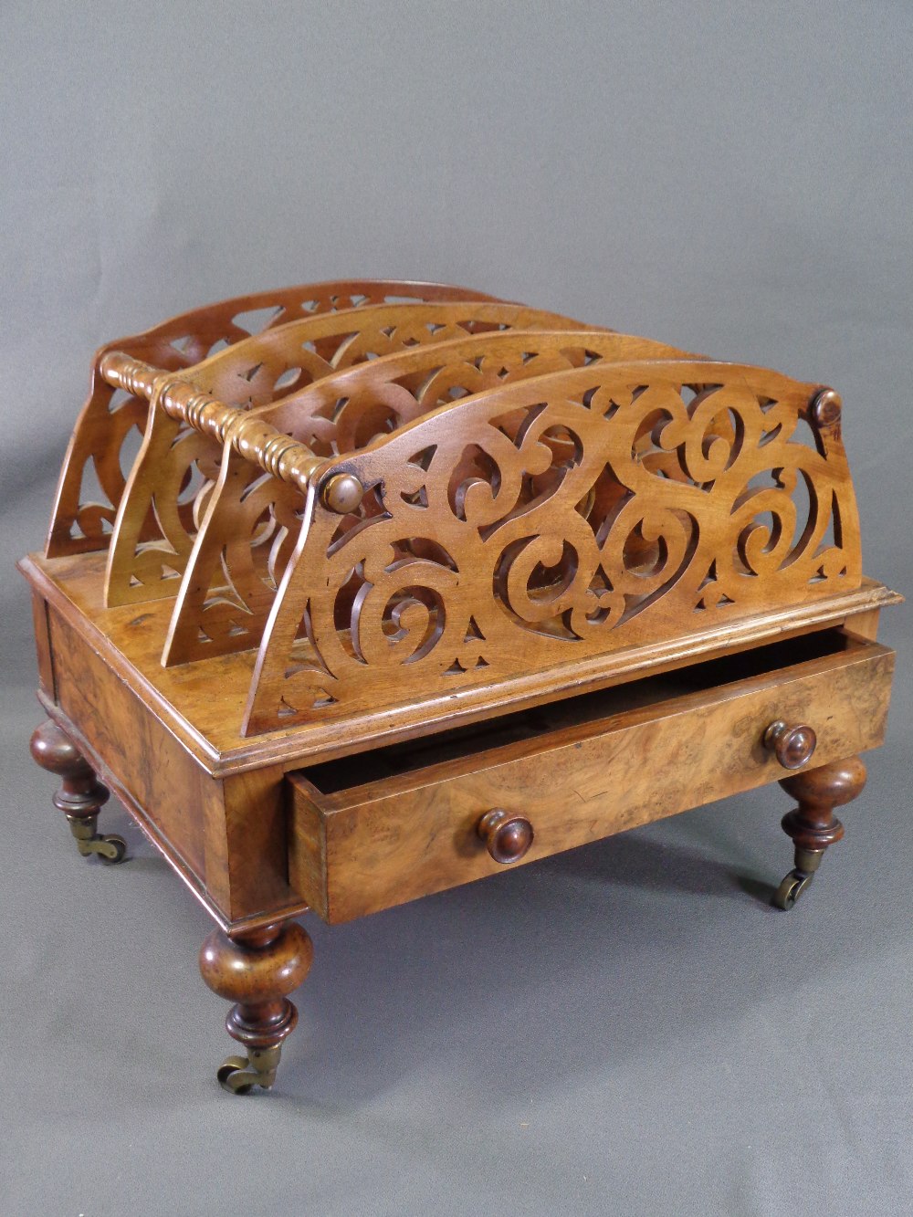 VICTORIAN CANTERBURY in walnut, three divisional fretwork sections with base drawer, on turned