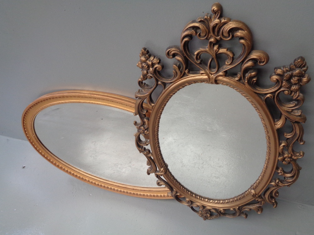 MIRRORS (two) - a gilt framed oval with bevelled glass, 57 x 93cms and an ornate mirror