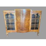 BURR WALNUT BOOKCASE - Queen Anne style with two glazed doors either side of a bow front, on