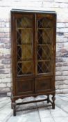 EARLY 20TH CENTURY CARVED OAK & LEADED GLASS BOOKCASE with applied mouldings, turned cup and cover