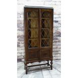 EARLY 20TH CENTURY CARVED OAK & LEADED GLASS BOOKCASE with applied mouldings, turned cup and cover