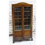EARLY 20TH CENTURY STAINED OAK & LEADED GLASS BOOKCASE, arched top and scrolled bracket feet, 183cms