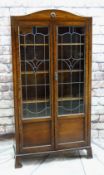 EARLY 20TH CENTURY STAINED OAK & LEADED GLASS BOOKCASE, arched top and scrolled bracket feet, 183cms