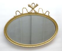 VICTORIAN OVAL GILT GESSO WALL MIRROR, ribbon and trophy cresting, 74 x 94cms