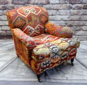 GEORGE SMITH HOWARD-STYLE ARMCHAIR, upholstered in Turkish kilim, turned legs, brass castors, labels