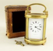 FRENCH BRASS OVAL CARRIAGE CLOCK, the enamel white dial with Roman numeral chapter ring and