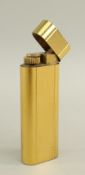 CARTIER GOLD PLATED CIGARETTE LIGHTER with oval section and engine turned decoration Condition: dent