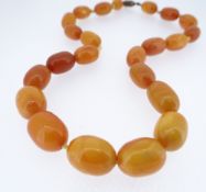 STRING OF 23 AMBER BUTTERSCOTCH BEADS, of graduating size, 39.5cms long, 23.9gms Condition: